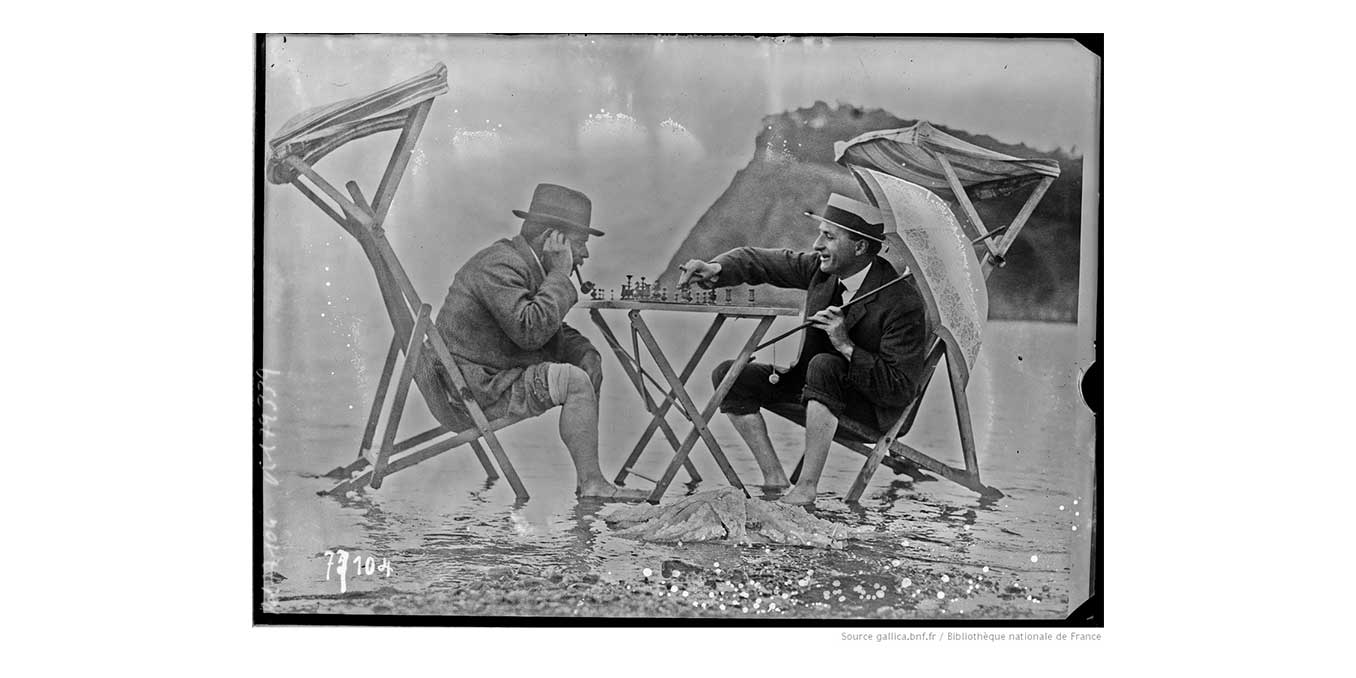 Scènes de plage [2 hommes jouant aux échecs les pieds dans l'eau] : [photographie de presse] / [Agence Rol]